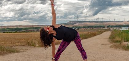 Outdoor fitness scene of a woman stretching on a dirt path in Soto de Cerrato amidst scenic landscapes.